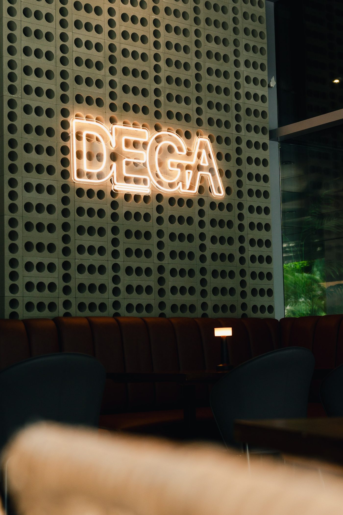 Letrero de neón de DEGA sobre la banca de cuero